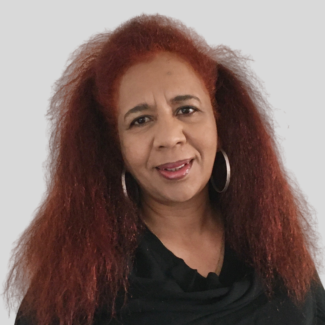 Tamaduer Ali wearing a black top and hoop earrings