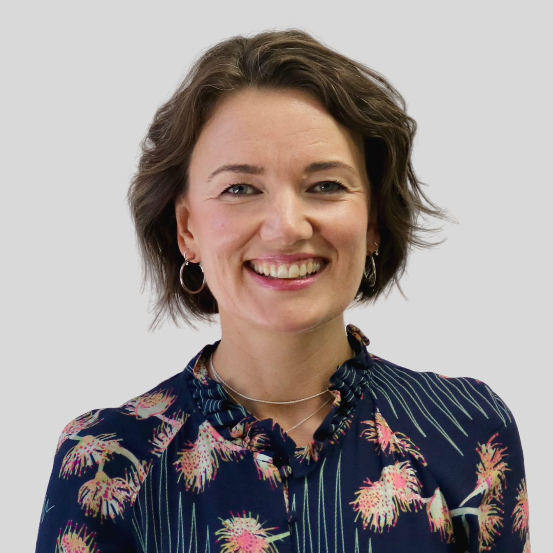 Becky Giles wearing a blue shirt with pink wattle flowers on it