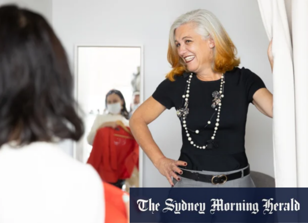 Sydney Morning Herald article, Fitted for Work client Marcia Scott pulls back a change room curtain to show off her stylish clothing